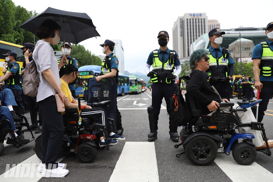 세종대로를 점거하며 탈시설조례 통과를 요구하는 장애인 활동가들. 그들 뒤로 멈춰 선 버스들이 보인다. 사진 강혜민