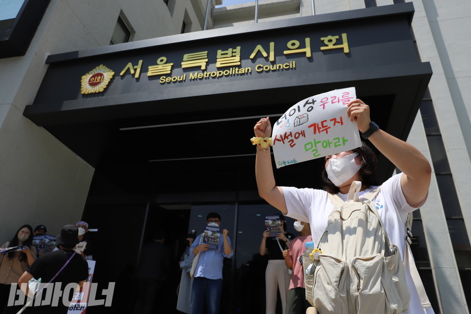 피플퍼스트 활동가가 “더 이상 우리를 시설에 가두지 말아라”라고 쓰인 팻말을 들고 있다. 사진 허현덕