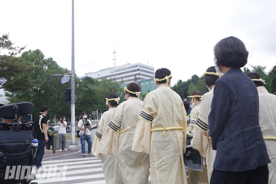 장애인 자녀를 둔 어머니들이 상여를 들고 행진하는 모습. 멀리 대통령 집무실이 있는 국방부 청사가 보인다. 사진 이슬하