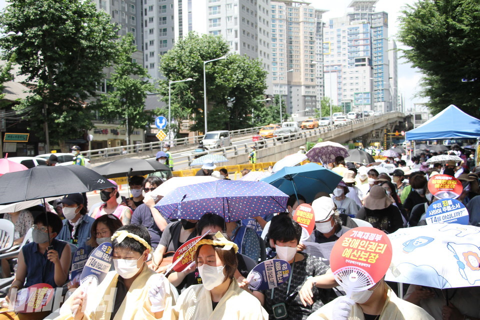 폭염주의보가 내려진 날씨에 장례식 참석자들이 부채와 양산 등을 이용해 햇빛을 가리고 있다. 사진 이슬하