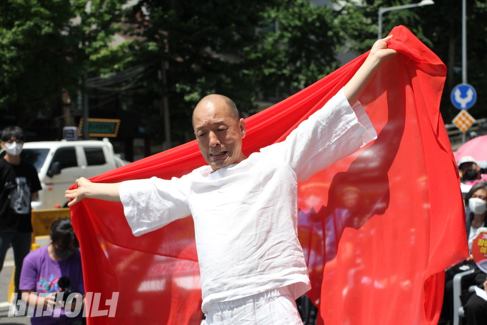 이삼헌 씨가 양팔을 쫙 벌려 빨간 천을 등 뒤로 활짝 펴고 있다. 사진 이슬하 