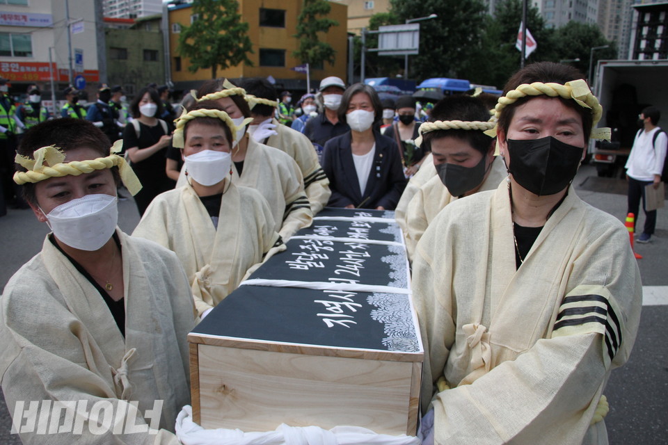 어머니들이 상복을 입고 관을 들고 행진하고 있다. 사진 이슬하