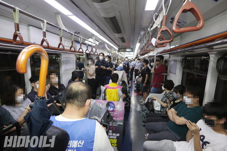 장애인 활동가들이 지하철에 탔다. 승객 대부분은 스마트폰을 보고 있다. 사진 이슬하