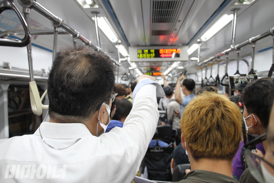 한 승객이 “장애인도 아닌  ‘멀쩡한’ 사람이 나를 쳤다”고 손가락질을 하며 시위에 항의하고 있다. 사진 이슬하