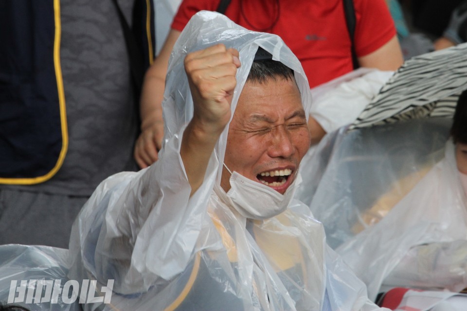 비를 맞고 환하게 웃으며 ‘투쟁’을 외치는 활동가. 사진 하민지