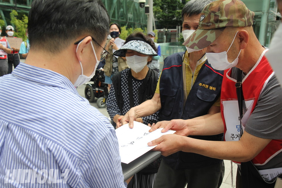 기자회견 참가자들이 비서실 직원에게 오 시장과의 면담요청서를 전달하고 있다. 사진 이슬하