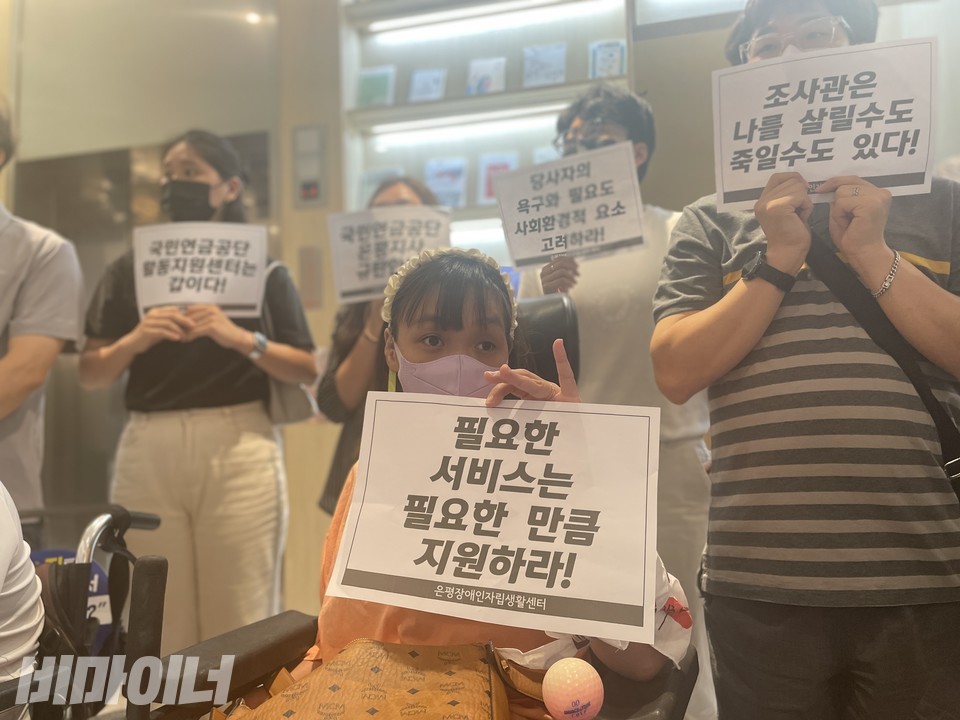 기자회견 참가자들. ‘필요한 서비스는 필요한 만큼 지원하라’, ‘국민연금공단 활동지원센터는 갑이다’, ‘국민연금공단 은평지사 규탄한다’, ‘당사자의 욕구와 필요도 사회환경적 요소 고려하라’, ‘조사관은 나를 살릴 수도 죽일 수도 있다’라고 적힌 피켓을 들고 있다. 사진 하민지