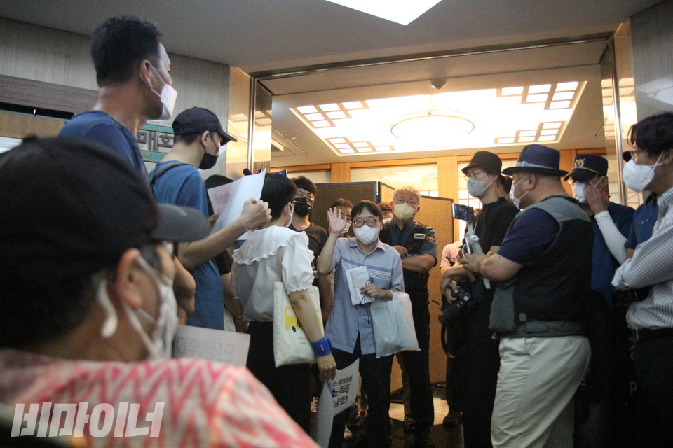 이수미 노들장애인자립생활센터 권익옹호활동가의 시선에 입구를 가로막고 있는 복지부 직원과 경찰이 보인다. 사진 이슬하