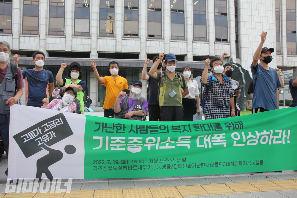 기자회견 참가자들이 구호를 외치고 있다. 이들 앞에 놓인 현수막에는 “고물가·고금리·고유가, 가난한 사람들의 복지 확대를 위해 기준중위소득 대폭 인상하라!”라고 적혀 있다. 사진 이슬하