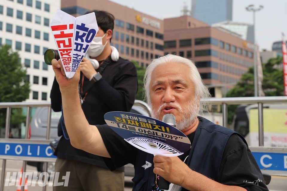 종이비행기를 들고 있는 박경석 대표. 종이비행기에 ‘정치가 책임져라! 장애인권리예산 보장’이라 적혀 있다. 사진 하민지