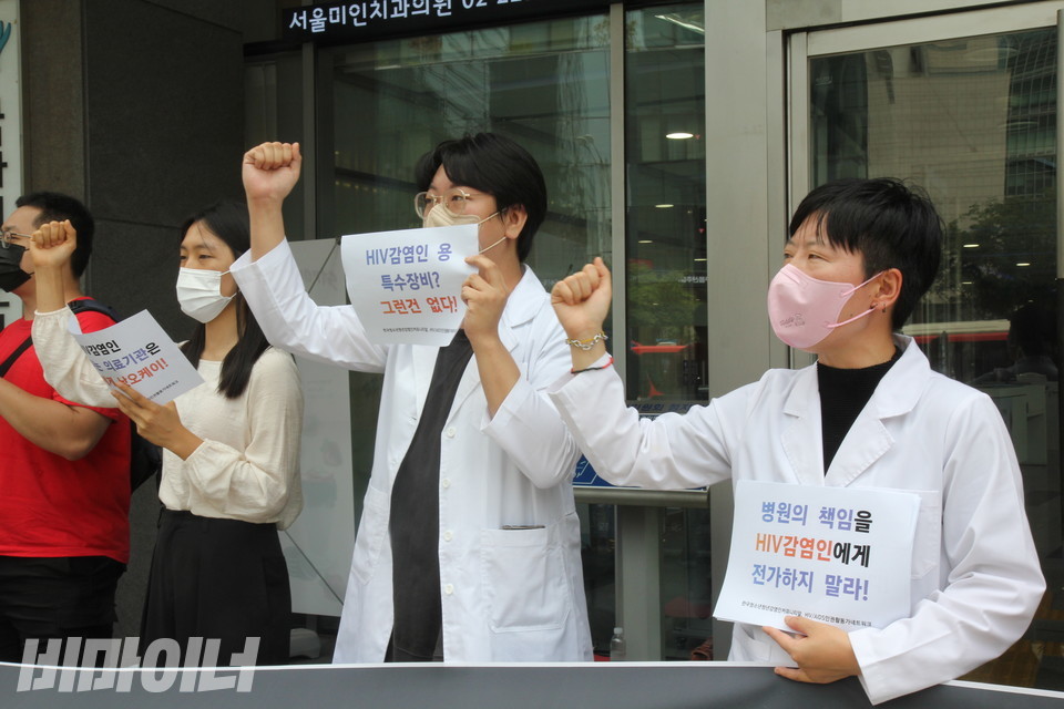 기자회견 참가자들이 구호를 외치고 있다. 손에 든 피켓에는 “병원의 책임을 HIV 감염인에게 전가하지 말라(마라)!”, “HIV 감염인용 특수장비? 그런 건 없다!”고 적혀 있다. 사진 이슬하