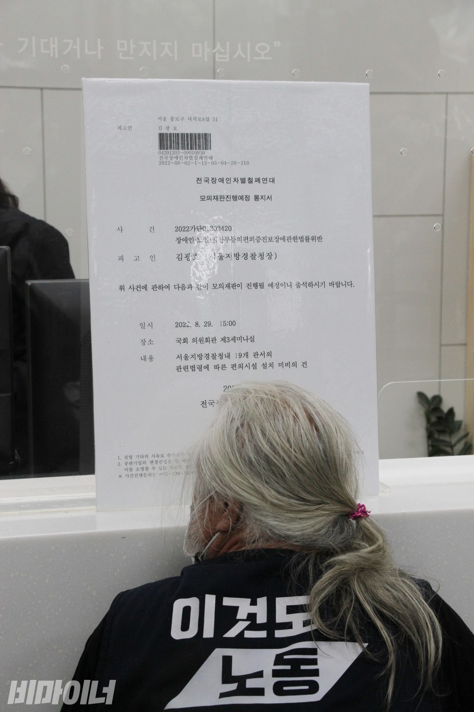 서울경찰청 1층 민원실. 테이블이 너무 높아, 휠체어 이용자가 제대로 이용하기 어렵다. 박경석 대표 얼굴 정면에 테이블 모서리가 위치하고 있다. 사진 하민지