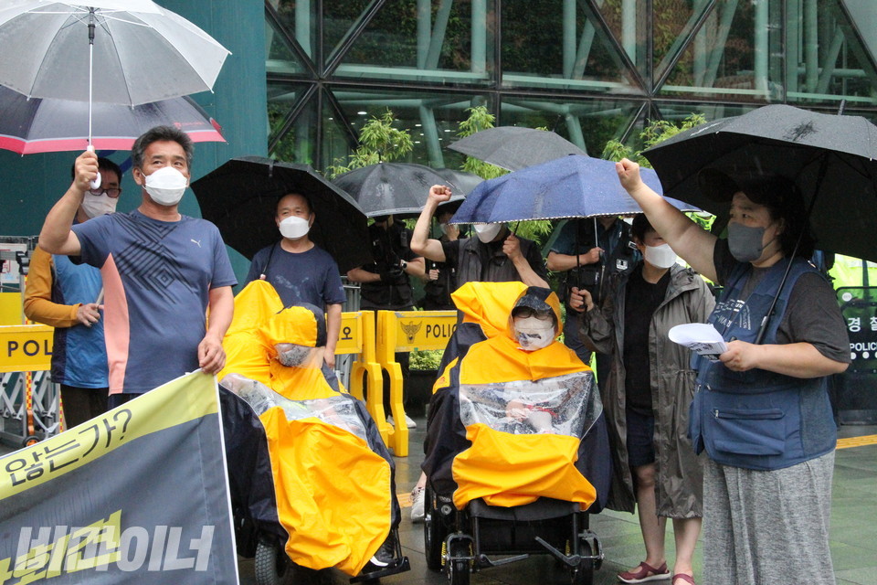 기자회견 참가자들이 빗속에서 구호를 외치고 있다. 사진 이슬하