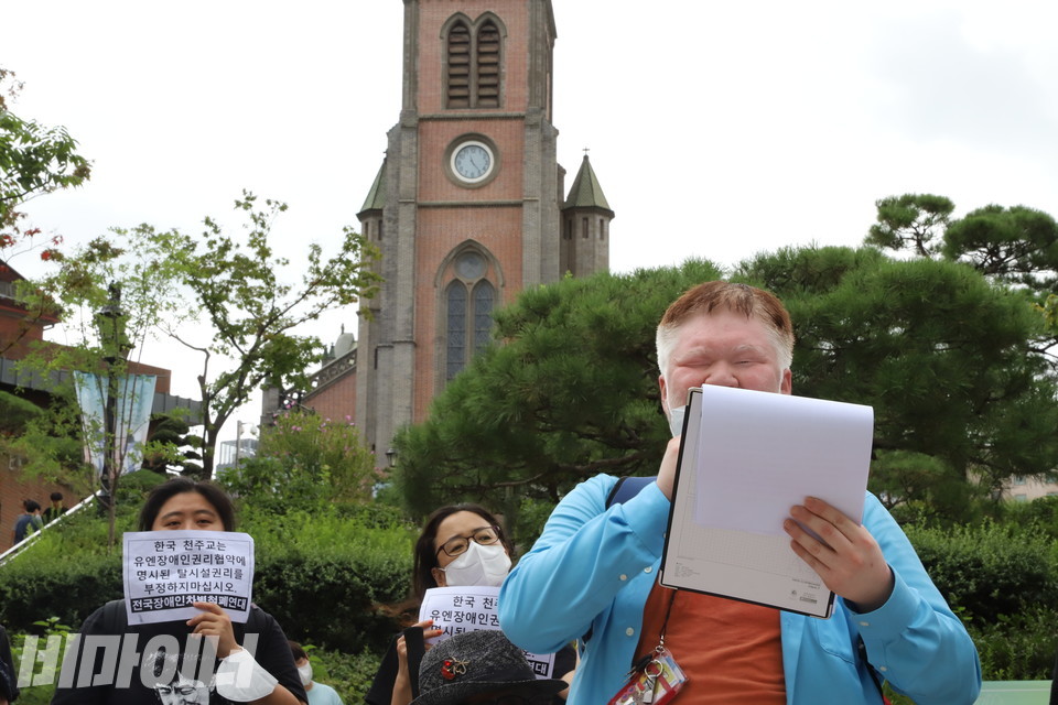 문석영 피플퍼스트서울센터 활동가가 기자회견에서 발언하고 있다. 그의 너머로 명동성당이 보인다. 사진 이슬하