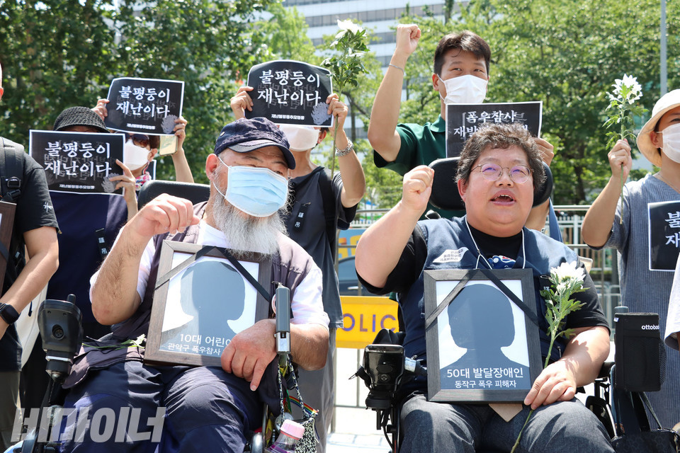 기자회견 참가자들이 “불평등이 재난이다”라고 적힌 피켓을 하늘 높이 들며 구호를 외치고 있다. 사진 강혜민