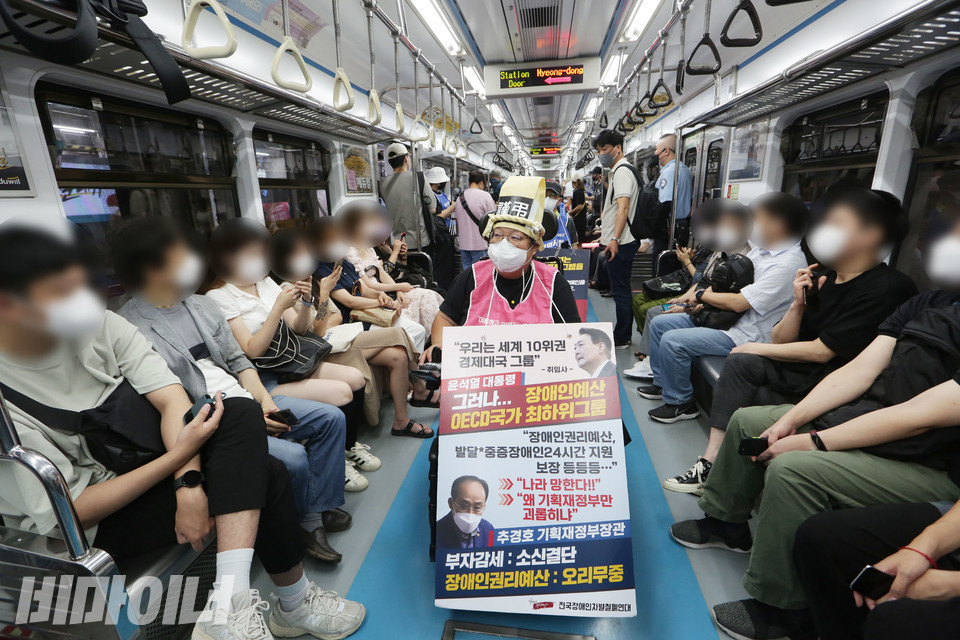 이형숙 서울시장애인자립생활센터협의회 대표가 장애인권리예산을 촉구하는 피켓을 들고 지하철에 올랐다. 사진 강혜민
