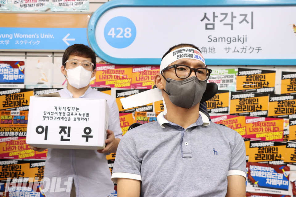 삭발을 마친 이진우 소장. 뒤에서 한 활동가가 이 소장의 잘린 머리카락이 담긴 하얀 상자를 들고 있다. 사진 강혜민 