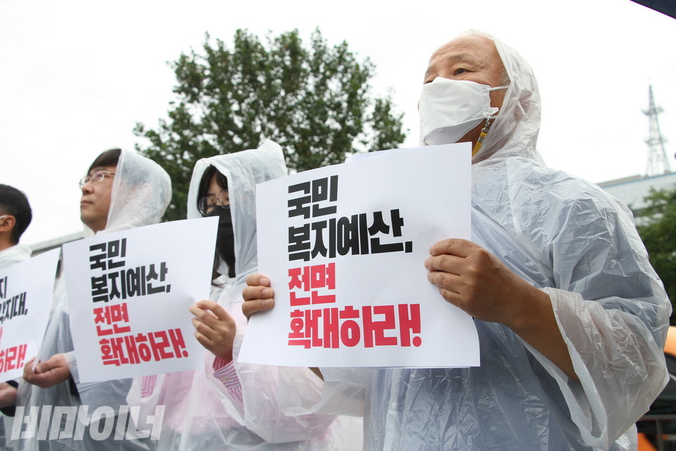 기자회견 참가자들이 피켓을 들고 있다. 피켓에는 “국민복지예산, 전면 확대하라!”고 적혀있다. 사진 이슬하
