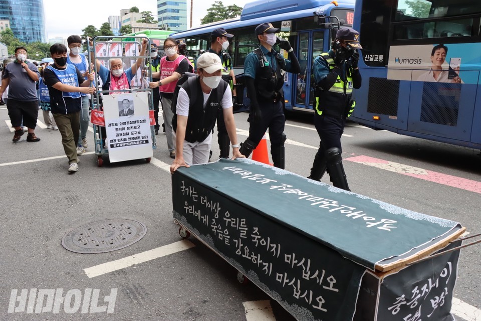 행진하는 전장연 활동가들. 한 활동가가 장애인의 죽음을 상징하는 가짜 관을 끌고 가고 있다. 사진 하민지