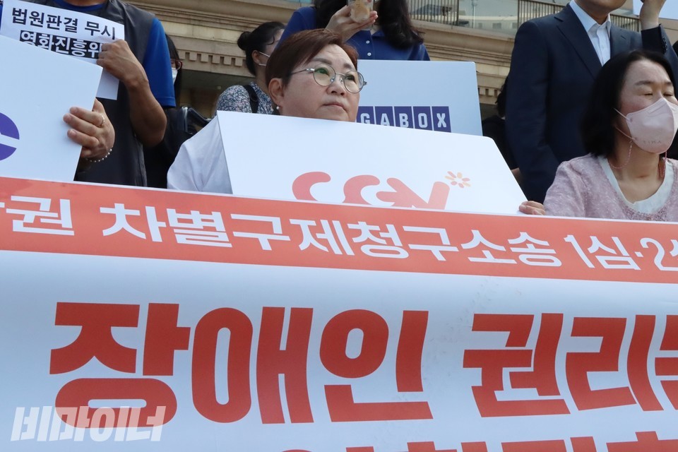 박김영희 대표가 CJ CGV로고가 삽입된 피켓을 들고 있다. 사진 하민지