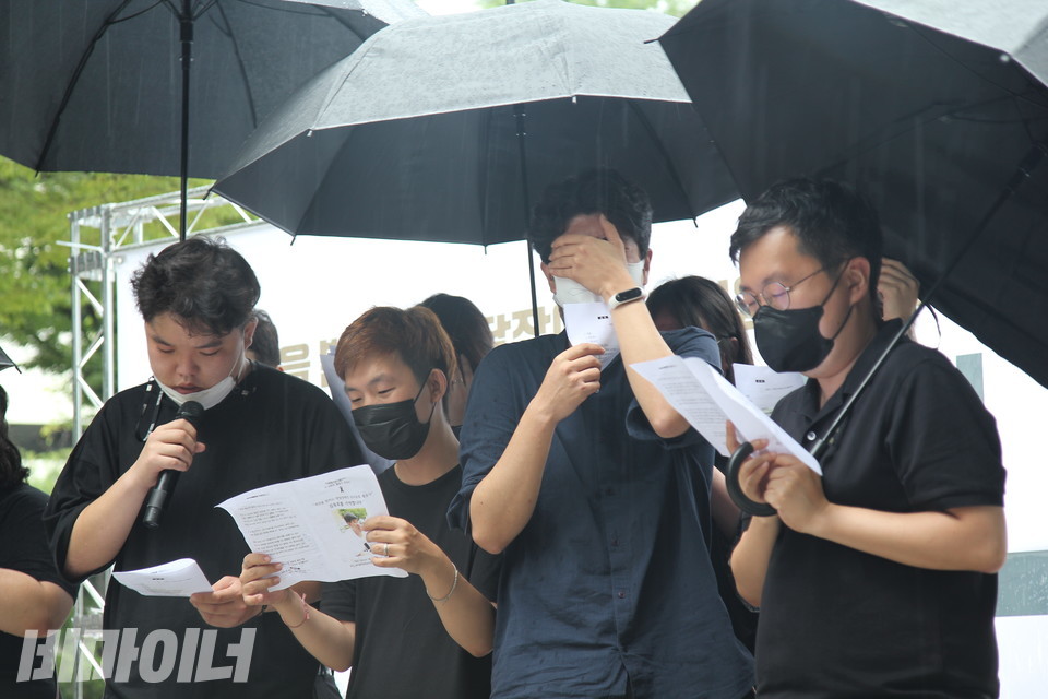 폭우가 쏟아지는 추모식에서 김대범 활동가(맨 왼쪽)가 피플퍼스트 활동가들과 함께 노래를 부르고 있다. 문혁 피플퍼스트성북센터 활동가가 얼굴을 가리고 오열하고 있다. 사진 이슬하