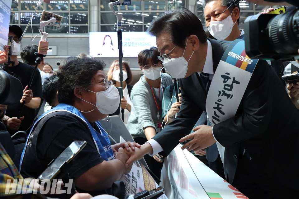 이형숙 서울시장애인자립생활센터협의회 회장이 이재명 당대표의 손을 꼭 붙잡고 장애인권리예산 보장에 대해 이야기하고 있다. 사진 강혜민 