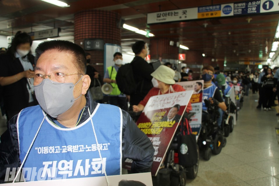권달주 대표 뒤로 장애인 활동가들이 줄지어 있다. 사진 하민지