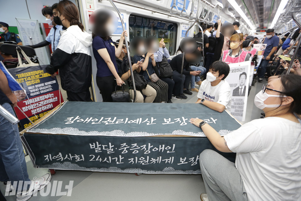 장애인권리예산이 보장되지 않아 죽어간 장애인들의 삶을 의미하는 가짜 관을 활동가들이 이동시키고 있다. 관에는 “장애인권리예산 보장하라. 발달중증장애인 지역사회 24시간 지원체계 보장하라”고 적힌 까만 천이 덮여 있다. 사진 강혜민