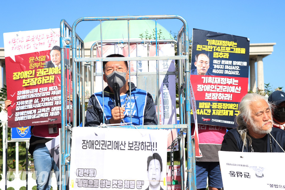 철창 속 권달주 전장연 상임공동대표가 권성동 국민의힘 원내대표의 발언을 규탄하며 장애인권리예산 보장을 촉구하고 있다. 사진 강혜민 