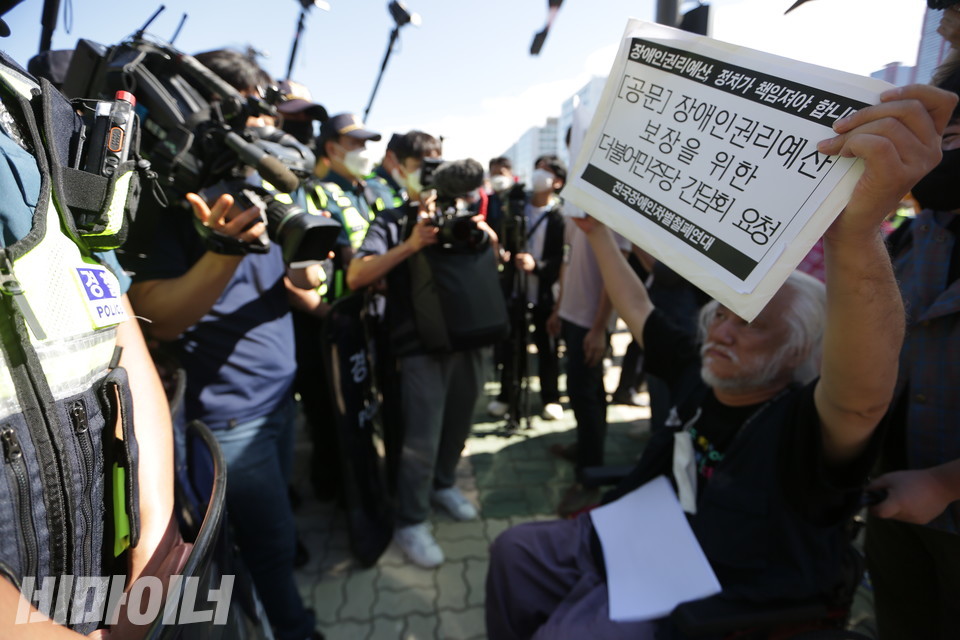 박경석 대표가 더불어민주당에 장애인권리예산 보장 관련 간담회를 요청하는 공문을 들고 있다. 경찰이 그의 국회 출입을 가로막고 있다. 사진 강혜민 