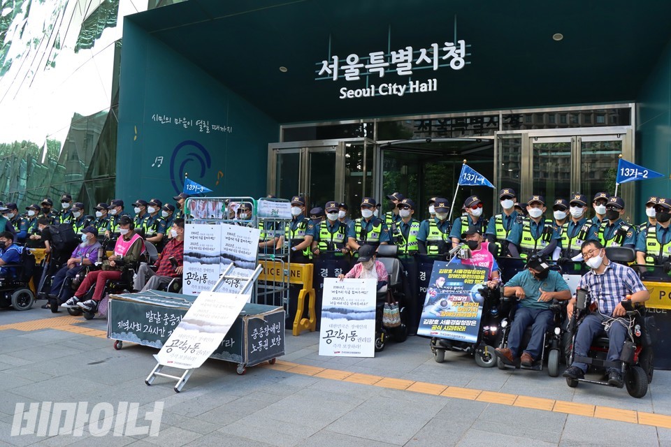 오세훈 시장에게 편지를 쓰기 위해 서울시청 정문 앞에 모인 장애인 활동가들. 경찰 수십 명이 정문 앞을 방패로 막아섰다. 사진 하민지