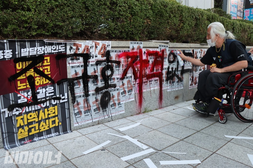 박경석 전장연 상임공동대표가 국민연금공단 서울북부지역본부 외벽에 스프레이로 ‘조규홍 자격 없다’라고 썼다. 사진 하민지