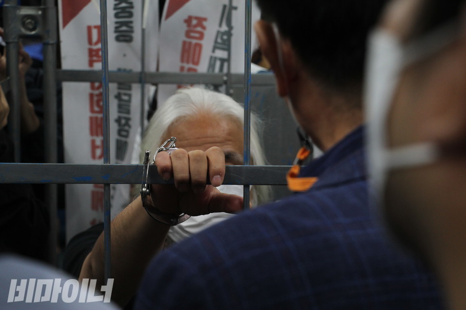 한 승객이 박경석 대표와 마주 서 시위에 대한 반감을 표출하고 있다. 승객의 어깨 너머로 수갑으로 묶인 박경석 대표의 손이 보인다. 사진 이슬하 