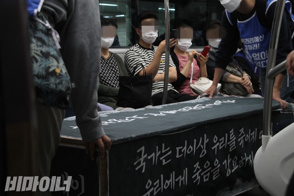 지하철 안에서 활동가들이 가짜 관을 옮기고 있다. 사진 이슬하