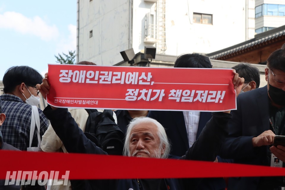 ‘장애인권리예산, 정치가 책임져라!’라고 적힌 피켓을 든 박경석 대표. 사진 하민지