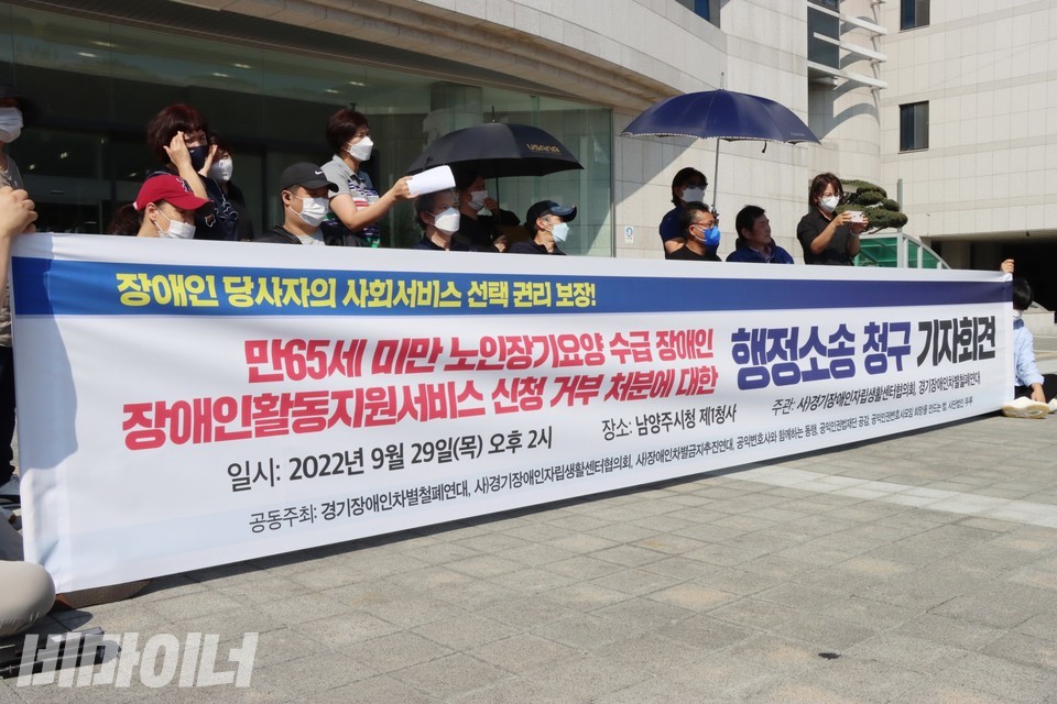 남양주시청 앞 기자회견 현장. 현수막에 ‘장애인 당사자의 사회서비스 선택 권리 보장! 만 65세 미만 노인장기요양 수급 장애인, 장애인활동지원서비스 신청 거부 처분에 대한 행정소송 청구 기자회견’이라 적혀 있다. 사진 하민지
