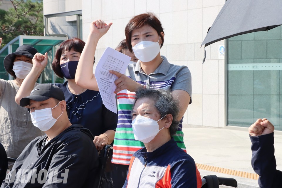 종이를 들고 ‘투쟁’을 외치는 사람이 지영 씨. 지영 씨는 종이로 재영 씨 얼굴 위에 떨어지는 햇빛을 가리고 있다. 사진 하민지