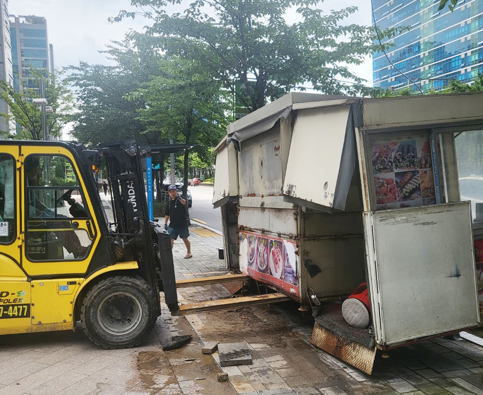 8월 8일 폭우로 가산디지털단지역 일대가 물에 잠기면서 노점상 마차가 큰 피해를 입었다. 휩쓸려 나간 포장마차를 중장비로 들어 올리고 있다. 사진 이범석