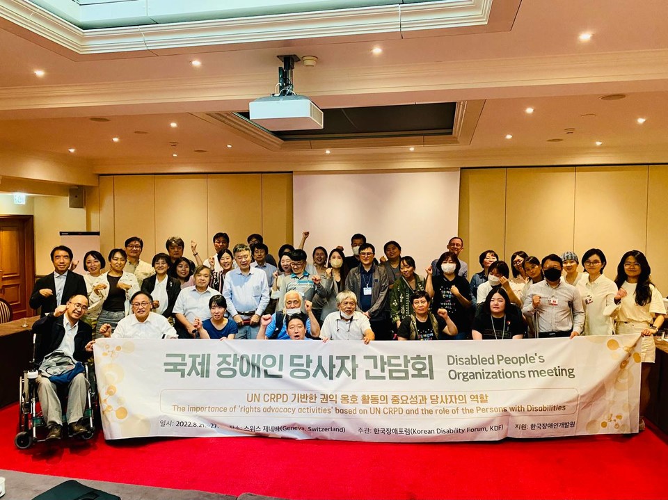 한국 일본 장애계, 스티븐 앨런 발리더티재단 대표가 함께 모여 장애계 현안에 대한 이야기를 나눈 후 기념 촬영을 하는 모습. 현수막에는 “국제 장애인 당사자 간담회”라고 적혀 있다. 사진 한국장애포럼