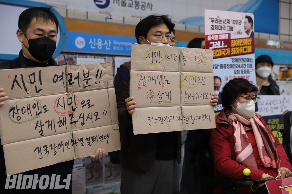 마포가온센터 활동가들이 '장애인도 시민으로 살게 해주십시오'라고 적힌 피켓을 들고 삼각지역 승강장에서 아침 삭발 투쟁을 하고 있다. 사진 복건우
