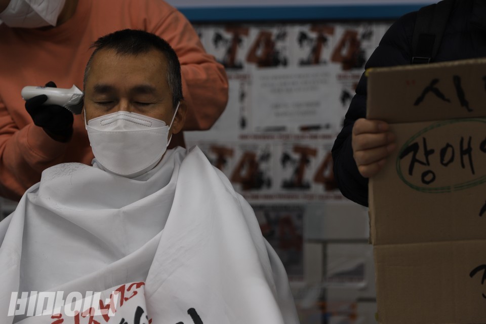 삭발 중인 홍 활동가가 눈을 감고 생각에 잠겨 있다. 사진 복건우