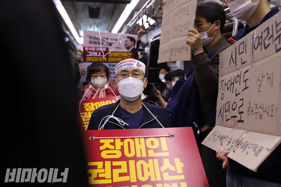 혜화역으로 향하는 지하철을 탄 홍 활동가 옆과 뒤로 피켓을 든 활동가들이 줄지어 있다. 사진 복건우