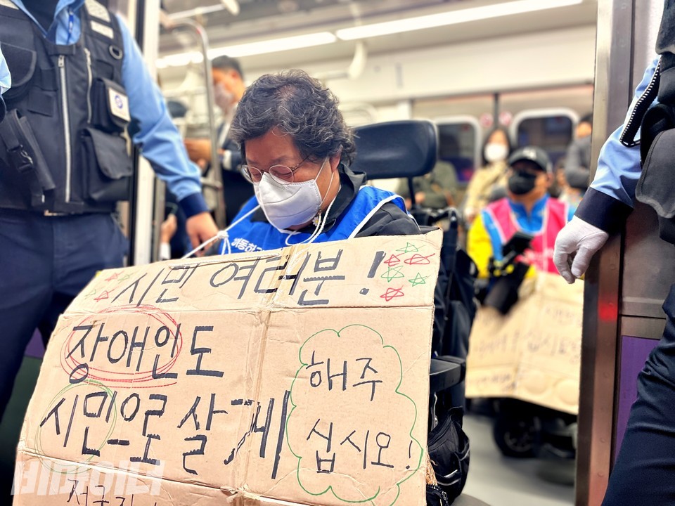 이형숙 서울시장애인자립생활센터협의회 회장이 ‘시민 여러분! 장애인도 시민으로 살게 해주십시오’라고 적은 피켓을 목에 걸고 고개를 숙이고 있다. 사진 하민지