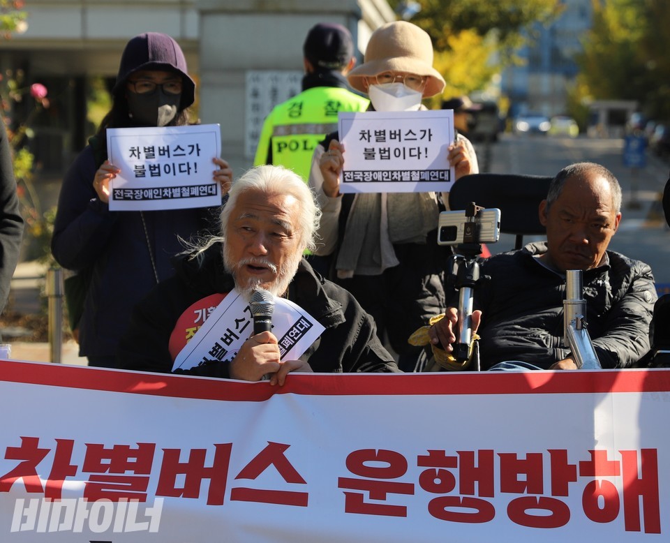 박경석 대표는 이날 기자회견에서 휠체어가 오르지 못하는 계단버스가 장애인의 이동권을 고려하지 않는 ‘차별버스’라고 비판했다. 박경석 대표 뒤로 장애인운동 활동가들이 ‘차별버스가 불법이다’는 문구가 적힌 손팻말을 들고 있다. 사진 복건우