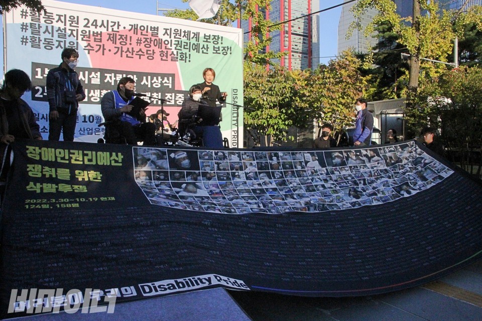 커다란 현수막이 펼쳐져 있다. 158명의 삭발결의자와 이름, 투쟁결의문 중 일부가 빼곡히 나열돼 있다. 사진 하민지