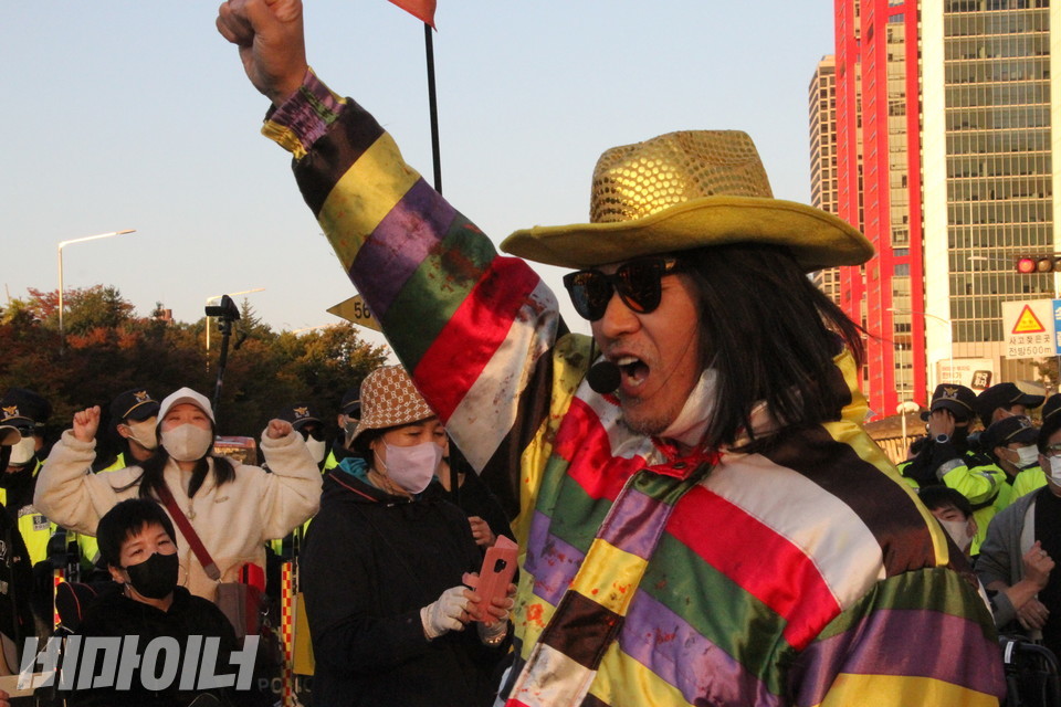 의상을 갈아입은 야마가타트윅스터가 노래 중이다. 한 활동가가 두 손을 하늘로 뻗으며 환호하고 있다. 사진 하민지