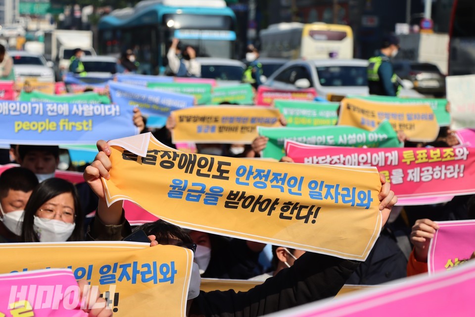 제9회 한국피플퍼스트대회 참가자들이 발달장애인 권리 보장을 촉구하는 내용이 적힌 손팻말을 들어보이고 있다. 사진 복건우
