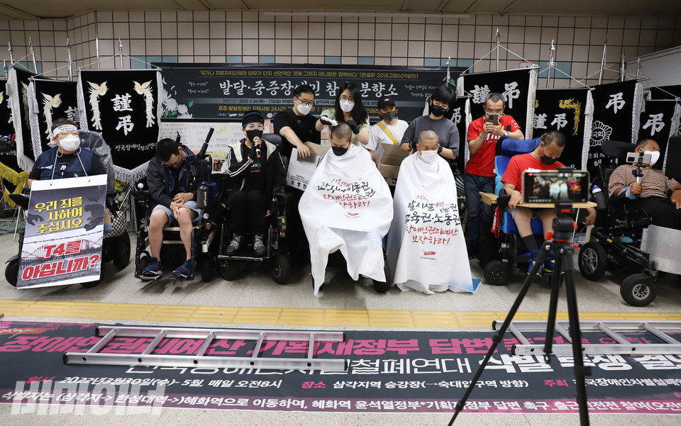 6월 24일, 삼각지역에 설치된 발달·중증장애인 참사 분향소 앞에서 민들레장애인야학  오명진·김선철 학생이 삭발 투쟁을 하고 있다. 인천에서 온 활동가들이 함께하고 있다. 사진 강혜민 