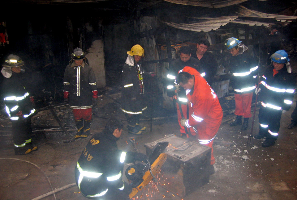 2005년 경기도 안양의 바울선교원 사건. 모든 것이 전소된 후 남은 것은 금고 하나였다. 소방대원들이 전기톱으로 금고를 열고 있다. 그 안에는 거주인들의 신분증과 도장, 통장이 모아져 있었다. 사진 제공 장애와인권발바닥행동