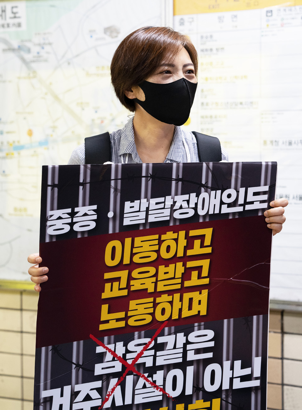 8월 25일, 장애인권리예산 보장을 촉구하는 지하철 선전전에 참가한 김정하 활동가. ‘중증·발달장애인도 이동하고 교육받고 노동하며 감옥 같은 거주시설이 아닌 지역사회에 살자’고 적힌 피켓을 들고 있다. 사진 현다혜